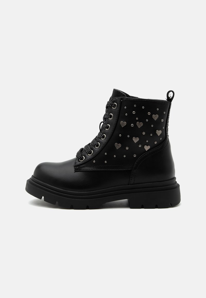 Bottine noire à semelle épaisse, lacets à l'avant, avec décorations en métal en forme de cœur et de clous ronds sur le panneau latéral.