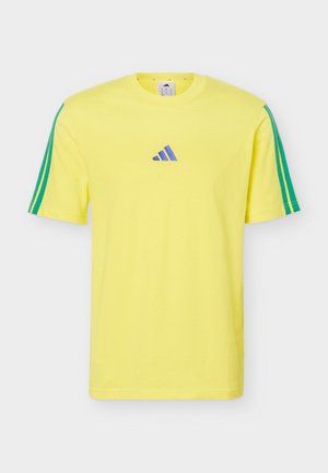 Φωτεινό κίτρινο κοντομάνικο μπλουζάκι με πράσινες ρίγες στα μανίκια και ένα μικρό μπλε λογότυπο Adidas στο κέντρο του στήθους.