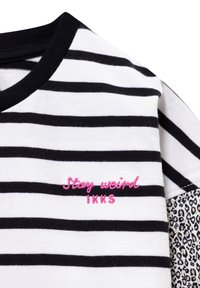 Gestreepte zwart-witte katoenen t-shirt met een roze geborduurde tekst "Blijf vreemd" en een accent van luipaardprint op de mouwen.