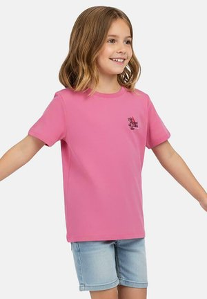 Roze T-shirt met korte mouwen van zacht materiaal, met een klein grafisch ontwerp op de borst. Gecombineerd met lichtgekleurde denim shorts.