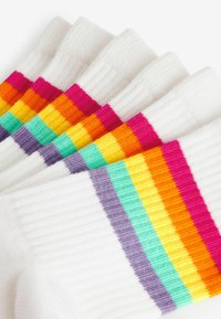 Biele ponožky s horizontálnymi pruhmi v ružovej, oranžovej, žltej, zelenej a fialovej farbe. Žebrovaná textúra s mäkkým pleteným povrchom.