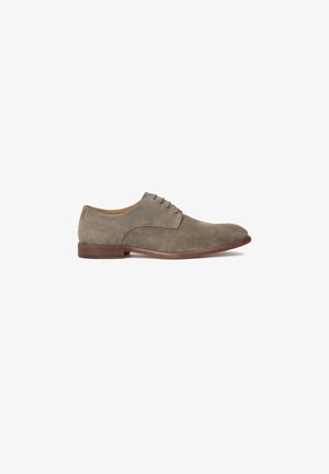 Zapato oxford de ante gris con punta redondeada, diseño de cordones y suela de goma marrón oscuro. Textura suave con detalles de costura sutil.