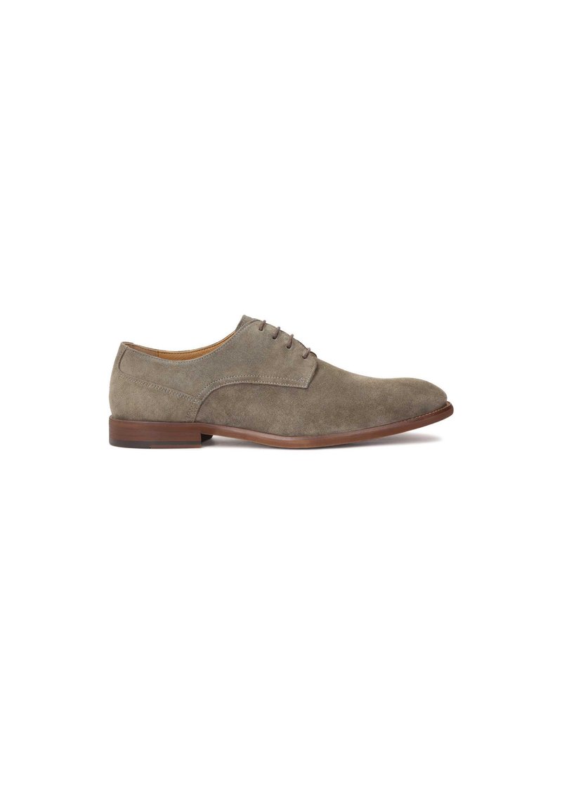 Chaussure oxford en daim gris avec un bout rond, un design à lacets et une semelle en caoutchouc marron foncé. Texture lisse avec des détails de couture subtils.