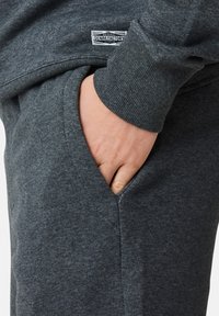 Szary sweter z fakturowanej tkaniny, luźny krój i boczna kieszeń. Zawiera metkę z logo "DENIM FACTORY".