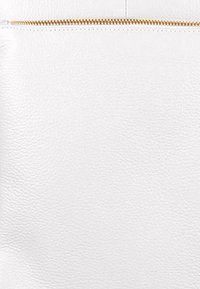 Witte leren tas met een gestructureerde oppervlakte, voorzien van een gouden ritssluiting aan de bovenkant. Eenvoudig ontwerp met minimale accenten.