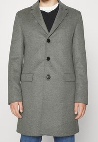 Cappotto grigio in lana con rever, tre bottoni neri e due tasche frontali, caratterizzato da una linea dritta e una texture liscia.