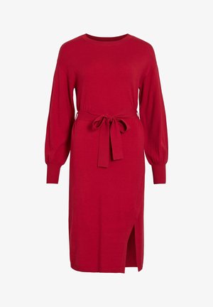 Sarkanais adīts kleitas ar garām pūkainām piedurknēm, pieguļoša jostas daļa un sānu šķirtne. Izgatavota no mīksta, elastīga materiāla. Vienkārša apaļa izgriezuma kakla līnija.