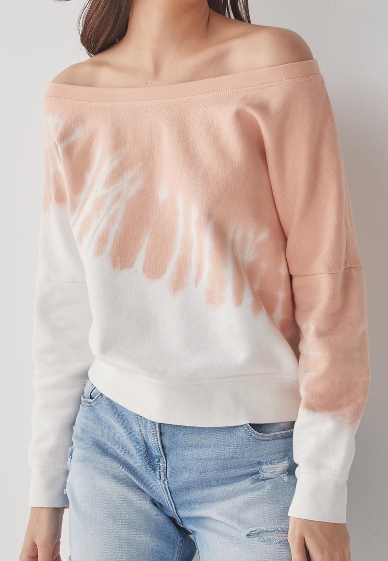 Mikina bez ramene ve světle broskvové a bílé barvě, s motivem tie-dye, dlouhými rukávy a měkkou, texturovanou tkaninou.