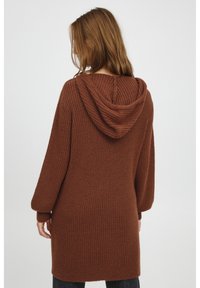 Maglione a coste marrone con cappuccio, lunghezza lunga, vestibilità comoda, tessuto testurizzato, presenta maniche larghe e un dettaglio cucito centrale sulla schiena.