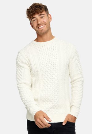 Knitted long-sleeve sweater in cream, featuring cable and diamond patterns, ribbed cuffs and hem, with a round neckline.
