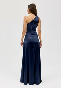 Námořnická saténová gown s jedním ramenem, nařaseným korzetem a splývavou sukní. Hladká textura, až na zem s elegantním siluetu.