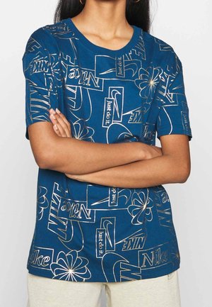 Blaues Baumwoll-T-Shirt mit verschiedenen Nike-Logos und floralen Mustern in goldener Konturierung, mit klassischem Rundhalsausschnitt und kurzen Ärmeln.