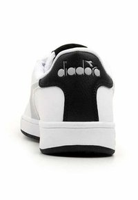 Sneaker bianco con un tallone nero, texture liscia, punta arrotondata e logo 'diadora' sul retro con un design a contrasto.
