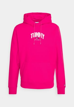 Sweat à capuche rose vif avec poche kangourou à l'avant, logo "Tommy Jeans" en lettres blanches et petit emblème de drapeau sur le bord de la manche.