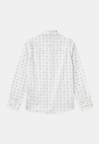 Witte lange mouwen shirt met een klein zwart patroon erdoorheen, klassieke kraag en knoopmanchetten. Lichtgewicht stof en rechte snit.