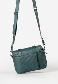 Teal leren schoudertas met een textuurafwerking, voorzien van een klepclosure, een verstelbare schouderriem en een ritssluiting aan de voorkant.