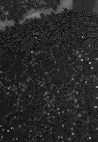 Schwarzer Spitzenstoff mit filigraner Blumenstickerei und Pailletten. Das Design ist geschichtet und zeigt unterschiedliche Texturen und Muster.