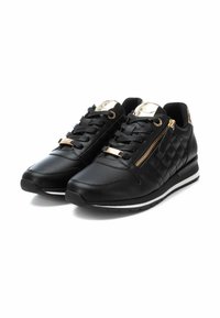 Zapatillas de cuero negro con paneles laterales acolchados, acentos dorados y un zipper lateral. Presenta cordones negros y una entresuela blanca.