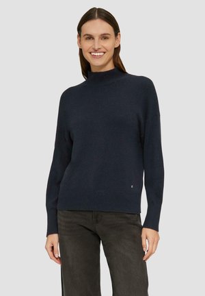 Marineblauer Pullover aus weichem Strickstoff. Hat einen hohen Kragen und eine lockere Passform mit gerippten Bündchen und Saum. Dezente Logodetails am unteren Ende.