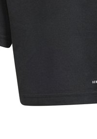 Black cotton t-shirt with a crew neckline, short sleeves, and a straight hem. Features a white logo detail near the bottom right.