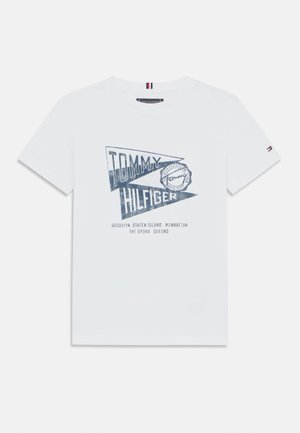 Camiseta blanca de algodón con estampado gráfico azul que incluye el texto "TOMMY HILFIGER" y nombres de ciudades, con mangas cortas y un pequeño detalle del logo en la manga.