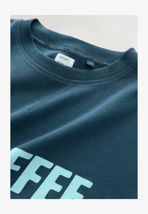 Felpa blu navy con colletto a girocollo, colletto a coste e scritta azzurra "COFFEE". Presenta una superficie di tessuto liscia e dettagli di cucitura visibili.