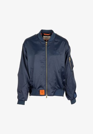 Granatowa kurtka bomber z przednim zamkiem błyskawicznym, prążkowanym kołnierzem i mankietami, kieszenią na zamek na rękawie oraz pomarańczową naszywką marki u dołu.