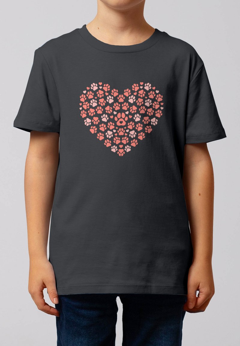 Enfant portant un t-shirt gris foncé avec un motif en forme de cœur composé d'empreintes de pattes d'animaux roses et rouges à l'avant.