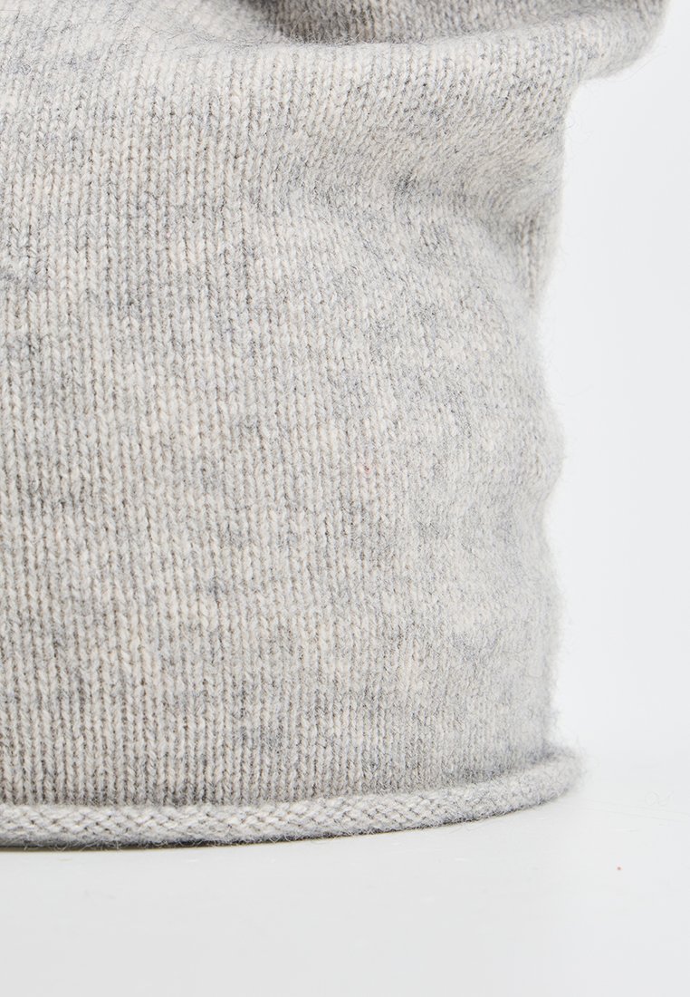 Jasnoszary, dziany wełniany beanie o subtelnym wzorze i lekkim zawinięciu na dolnej krawędzi, na jednolitym tle.