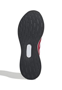 Shoe sole with a textured black rubber surface, featuring a white accent near the center and a contoured design for traction.