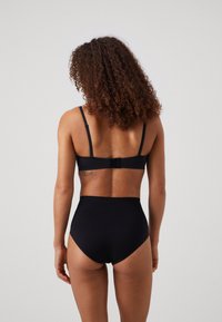 Black lingerie set featuring a bra with adjustable straps and a clasp, paired with high-waisted panties, smooth fabric, and minimalistic design.