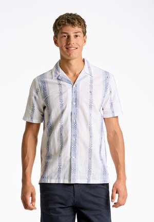 Camisa blanca de manga corta con patrones geométricos azules, frente abotonado y cuello relajado. Fabricada en un tejido ligero.