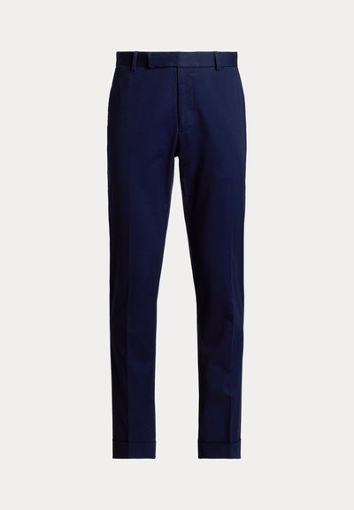 Námornícky modré slim-fit nohavice s opaskovými pútkami, predným zipsom a vyhrnutými lemami, zobrazené na jednoduchom svetlom pozadí.