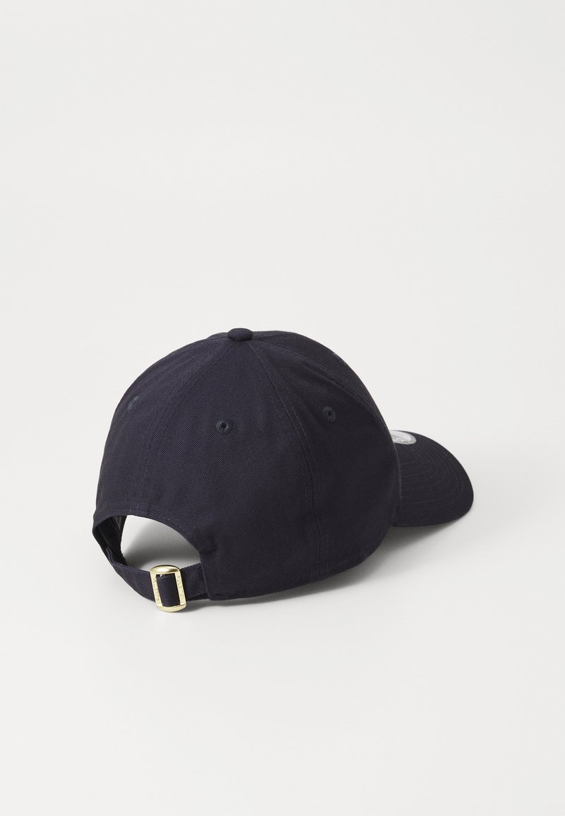 Navy blue baseball cap, cotton material, traditional curved brim, adjustable strap with gold hardware, six panels with ventilation holes.
