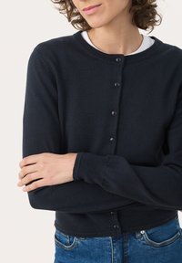 Marinefarbener Cardigan aus Strickstoff, mit Rundhalsausschnitt, langen Ärmeln und Knopfverschluss. Strukturiertes Finish und gerippter Saum.