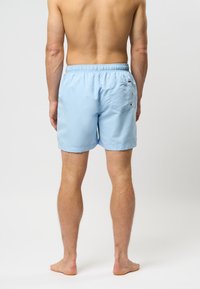 Lichtblauwe zwemshorts van gladde stof, met een elastische tailleband, een enkele achterzak en minimale stikdetails.