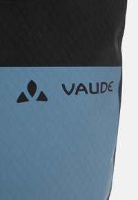 Il prodotto VAUDE in nero e blu chiaro presenta una superficie testurizzata e di pattern, con il nome del marchio stampato in nero sulla sezione blu.
