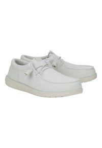 Zapatos de malla blanca con superficie texturizada, puntera redondeada y suela de goma plana. Presentan un diseño con cordones y detalles sutiles.