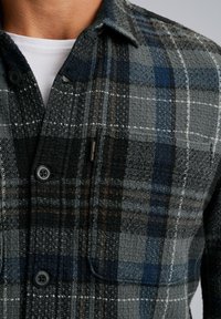 Grijze en blauwe geruite flanelshirt met gestructureerde stof, knoopsluiting en borstzak. Kenmerkt zich door contrasterende stiksels en een label.