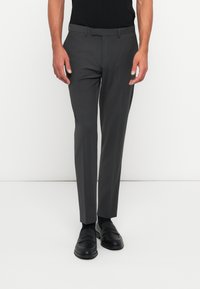 Gray dress trousers featuring a slim fit, smooth texture, belt loops, and a crease down the front. Paired with black loafers.