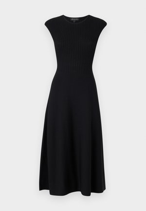 Robe noire tricotée avec une texture côtelée, sans manches, avec un corsage ajusté et une jupe fluide qui tombe sous le genou.