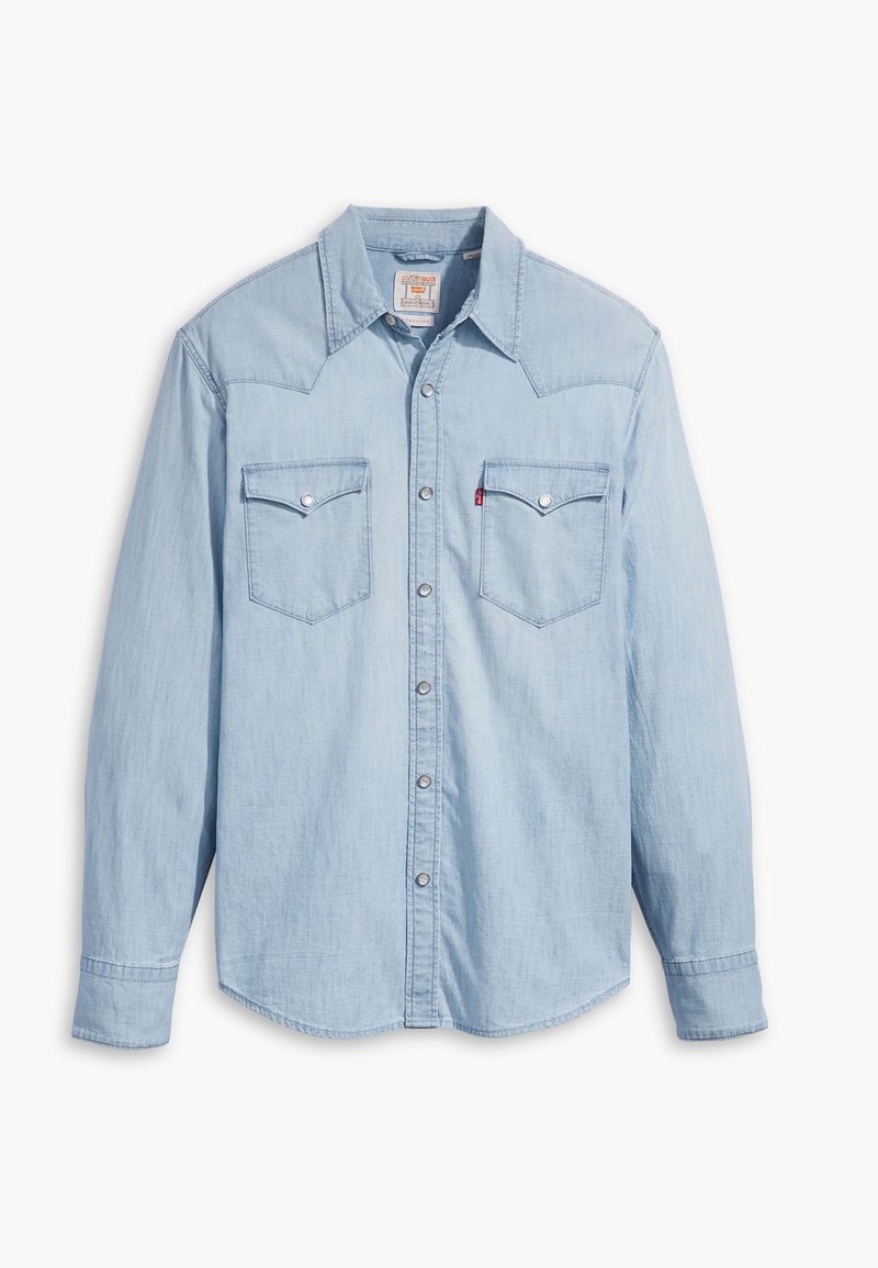 Chemise en denim bleu clair à manches longues avec fermeture boutonnée devant et deux poches poitrine à rabats boutonnés.
