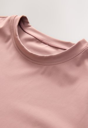Lichtroze shirt met korte mouwen en een ronde hals. Gladde textuur, minimale naden en een eenvoudig ontwerp gericht op comfort.