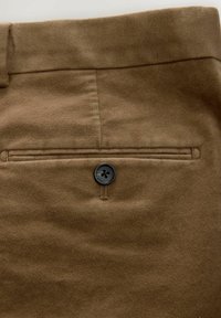 Braune Wollhose mit glatter Textur, ausgestattet mit einer einzelnen Gesäßtasche und einem schwarzen Knopfdetail auf der Taschendeckel.