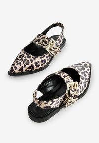 Leopardikuosislingback-kengät, joissa on terävä kärki, kultaiset varusteet ja musta litteä pohja. Ominaisuuksiin kuuluu leikattu sivu ja säädettävä hihna.