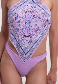 Eén deel badpak in lavendel kleur met een paisley-patroon op de driehoekige top, een hoge beenopening en een gladde textuur.