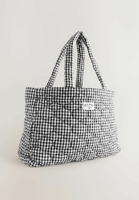 Black and white gingham quilted tote bag with a structured shape, padded texture, and dual handles. Label stitched on the front.