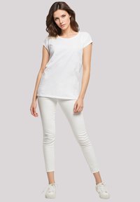 White short-sleeve t-shirt paired with white slim-fit pants and white sneakers. Simple design with a round neckline and smooth fabric texture.