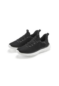 Schwarze Mesh-Sport Schuhe mit einer strukturierten Oberfläche, elastischen Schnürsenkeln und einer weißen Gummisohle. Leicht und im Slip-On-Design.