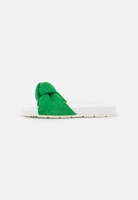 Mules en suede vert avec un dessus noué, semelle blanche rembourrée et finition texturée sur la partie verte.